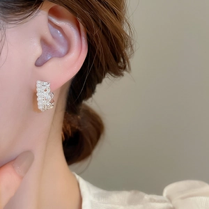 Close-up of elegant crown lace pearl earrings on model with silver metal details