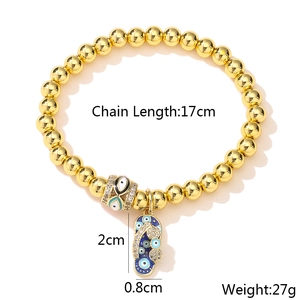 Detail of gold beaded bracelet with evil eye beads and rhinestone flip-flop charm
