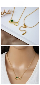 Detail of infinity gold necklace with green heart gem and pave stones on model