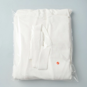 Close-up of white waffle knit cardigan set in transparent packaging with Size S label