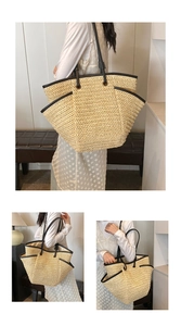 Fashionable woven straw tote bag with black leather straps shown on a model's shoulder