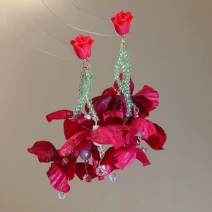 Detail of red fabric flower earrings with crystal tassels and green beaded strands