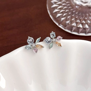 Detailed macro view of silver flower earrings with pastel zircon stones and petals