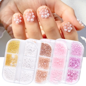 Macro detail of mixed sizes pearl beads and steel balls for nail art in storage box