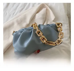 Detail showing high-quality leather texture and bold gold chain of the blue cloud bag