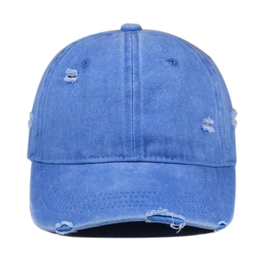 Close-up of blue distressed baseball cap with vintage frayed edges and torn hole detail