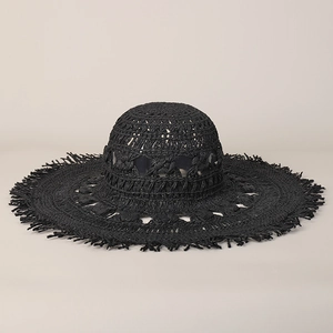 Vista dettagliata di un cappello da spiaggia nero in paglia intrecciata a mano