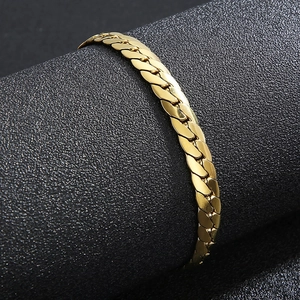Dettaglio macro di un bracciale a catena cubana dorata con maglie lucide e spesse