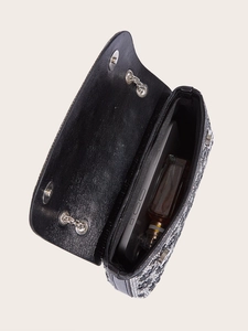 Interior view of black sunflower rhinestone evening bag showing phone and perfume capacity