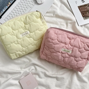 Detailansicht der gesteppten Kosmetiktaschen mit Herzmuster in Beige und zartem Rosa