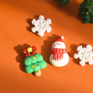 Close-up of Christmas resin accessories featuring snowman, tree and glitter snowflakes