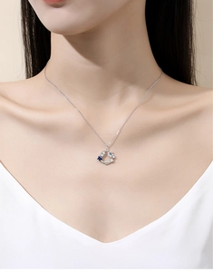 Detailed shot of S925 sterling silver star and moon necklace with blue cubic zirconia on neck