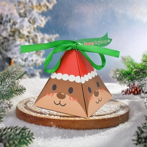 Detailed view of reindeer pyramid gift box on snow with pine branches and green ribbon