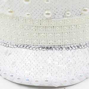 Close-up of white luxury party hat featuring sequins, pearls and sparkling rhinestones