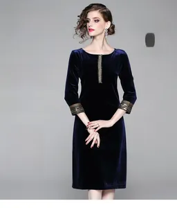 Dettaglio del ricamo sui polsini di un abito in velluto blu navy con decori di perline