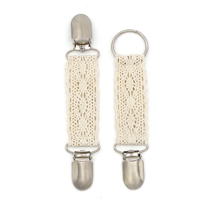 Detailed close-up of ivory lace hat clips with silver metal buckles for travel storage