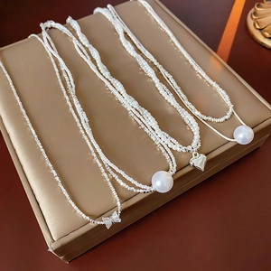Détails de quatre colliers élégants avec perles et cœurs sur un présentoir à bijoux