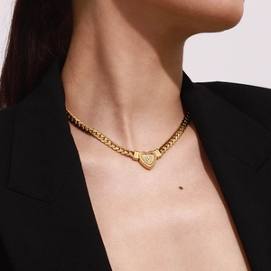 Elegant gold heart pendant necklace with crystal stone on a classic Cuban link chain
