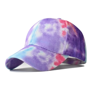 Detail of multi-color tie-dye stitching and ventilation holes on a cotton sun visor hat