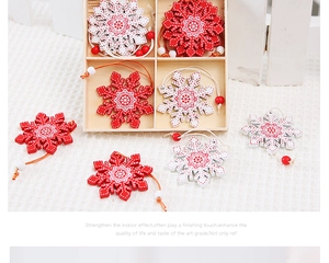 Close-up of wooden snowflake ornaments in red and white colors stored in a wood box
