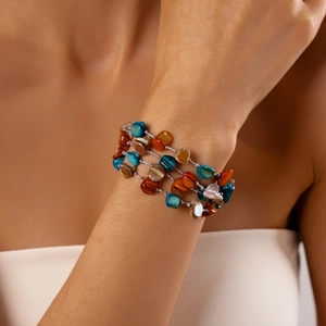 Detail of bohemian multilayered bead bracelet with colorful irregular stone and shell charms