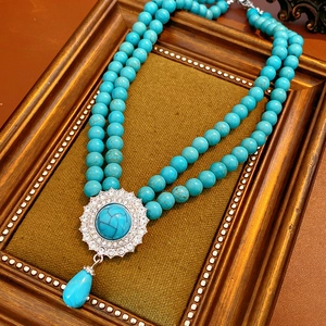 Detail of vintage double-layer turquoise beaded necklace with rhinestone drop pendant