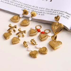 Golden heart, bow, shell, and pearl stainless steel earrings on a clean white background
