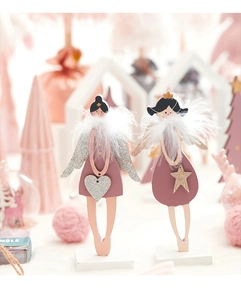 Détail des ornements d'anges en bois rose avec ailes pailletées et col en plumes blanches