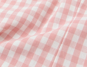 Nahaufnahme der atmungsaktiven rosa-weißen Gingham-Stoffstruktur mit weichen Falten
