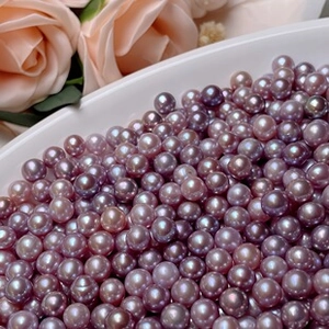 Macro detail of natural lavender freshwater pearls in a tray with soft floral background
