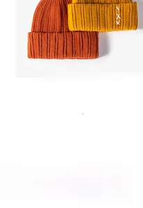 Detailed knit texture and white XXX cross-stitch embroidery on warm winter beanies