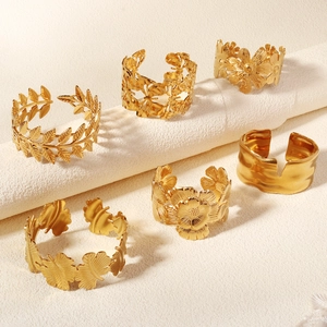 Detail of six gold-tone leaf and floral cuff bracelets with vintage geometric textures