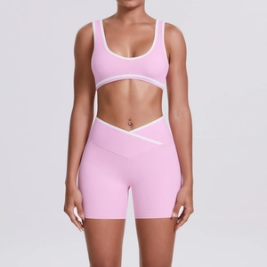 Close-up of pink yoga set showing U-neck bra and V-waist shorts with white trim