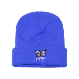 Détail du bonnet bleu avec broderie papillon violet et texte dreams en rose