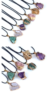 Macro detail of irregular raw crystal pendants with gold edges on black wax cords