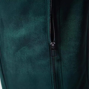Gros plan d'une veste en daim vert foncé avec fermeture éclair en métal argenté de qualité