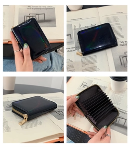 Macro detail of holographic black card holder showing organ-style slots and gold zipper