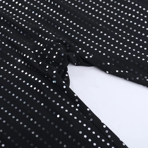 Vue macro du tissu noir avec paillettes argentées montrant la texture de la combinaison