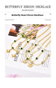 Detail of gold snake chain necklace featuring green heart zircons and butterfly pendant