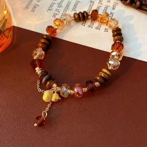 Bracelet en perles d'œil de tigre et bois avec pendentif gourde dorée sur cuir