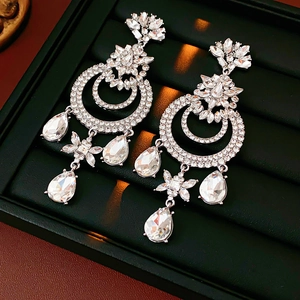 Détail de boucles d'oreilles vintage argentées avec cristaux dans un écrin noir luxueux