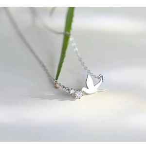 Macro detail of S925 sterling silver bird pendant with sparkling zircon stones
