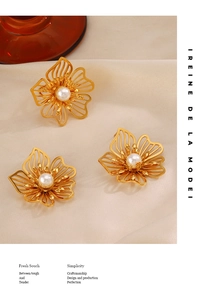 Detailed view of gold oversized flower earrings with white pearls on silk background