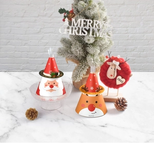 Détail de boîtes cadeaux de Noël coniques avec motifs de Père Noël et rennes festifs