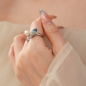 Detailed macro of a conch star ring with blue enamel and round white pearl