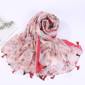 Detailed close-up of pink floral print pattern and soft fringe tassels on cotton scarf