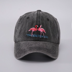 Close-up of pink flamingo embroidery on washed denim gray baseball cap fabric