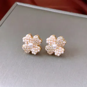 14K gold plated clover earrings with alternating pearls and zirconias on display