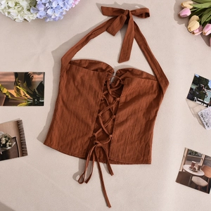 Dettaglio macro del crop top marrone allacciato al collo con tessuto a costine