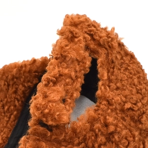 Close-up of thick brown teddy fleece fabric texture on a winter baseball cap